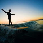 woman longboarding sunset silhouette